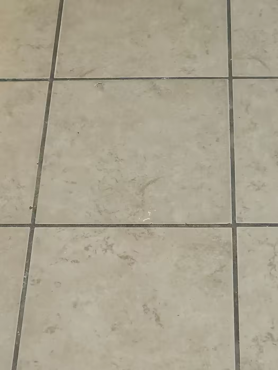 Before: Severely darkened grout lines in a residential kitchen.